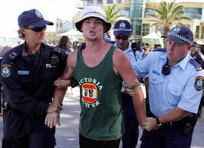 A male youth is arrested on Australia Day 2013 by police. It is believed he decided to "punch as many people as he could see" after hearing Triple J play 'Mackelmore' in the #1 spot on the Hottest 100