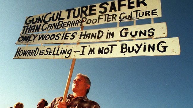 Protestors hold up offensive signs when confronted with Howard's gun laws, to no avail.